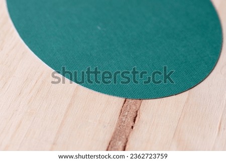 machine-cut green card stock ovoid shape on a plain wooden surface