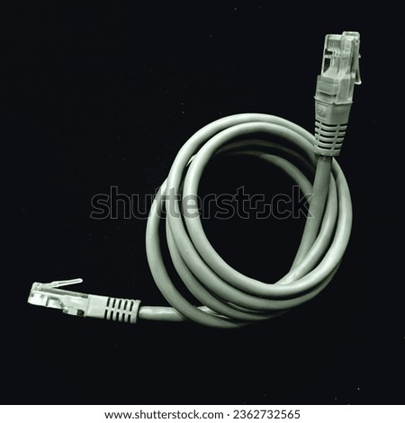 Lan cable for internet network connection, gray lan cable on a black background. Ethernet cable for computer or laptop with rj45 connector closeup Royalty-Free Stock Photo #2362732565