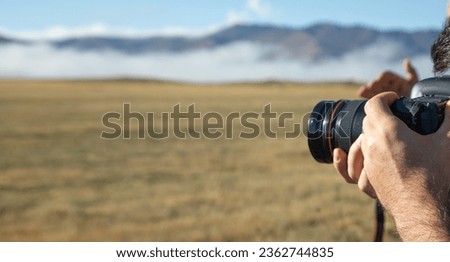 Man holding dslr camera in outdoor.