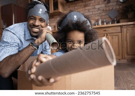 Head shot portrait happy family playing pirates having fun at home, engaged in funny activity on weekend together, smiling father with little daughter dressed homemade costumes looking at camera
