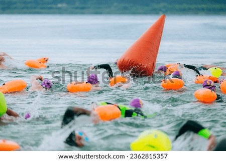 swimmers in open water at the start with a buoy Royalty-Free Stock Photo #2362815357
