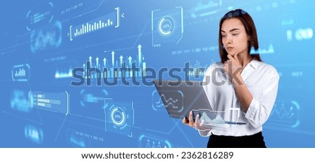 Thoughtful businesswoman looking at laptop, virtual screen hud with big data metrics, dashboard with analysis and glowing chart with indicators. Concept of investment and financial idea