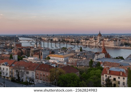 A picture of Budapest landmarks at sunset, such as the Hungarian Parliament, the Church of Stigmatisation of Saint Francis, the Saint Anne Parish Church, and the Szilagyi Dezso Square Reformed Church.