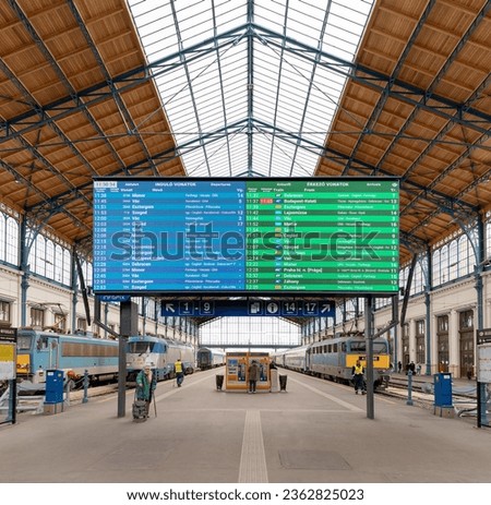 A picture of the Nyugati train station with a large timetable screen on display.