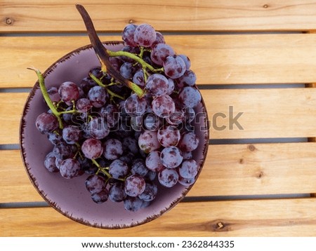 Red grapes on a wooden background. Ripe grapes close-up.