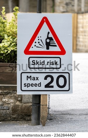 Skid risk maximum speed 20 mph sign red and white triangle