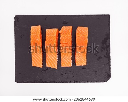 Salmon fish fillet on Slate stone. Red fish fillet close-up on a white background.