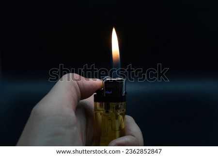 Image of flames on a dark background, orange flames created by a lighter are displayed. Royalty-Free Stock Photo #2362852847