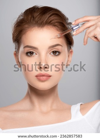 Woman getting cosmetic injection of  botox in forehead, closeup. Woman in beauty salon, plastic surgery clinic. Cosmetology procedures concept. Beauty treatment therapy.  