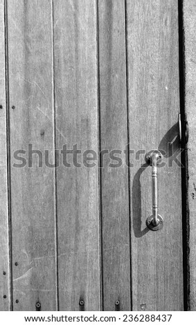 Old wooden wall background with a handle on - close the door.