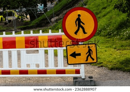Pedestrian Sign of a walking man in a red circle, arrow direction of movement