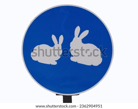 Road sign at the farm "Beware of rabbits". Road sign with rabbits. A blue road sign with two rabbits on it.