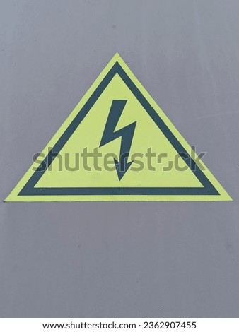 High voltage sign on a gray background. Danger symbol. Warning sign