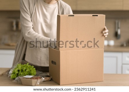 Cropped shot of woman producing packed fresh vegetables from cardboard box, receiving parcel from supermarket customer logistic service, opening paper container, preparing dinner Royalty-Free Stock Photo #2362911241