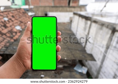 Close up of male hand holding smartphone with blank copy space screen. Smartphone green screen mockup