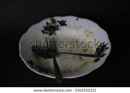 Used plates, spoons, forks on black background