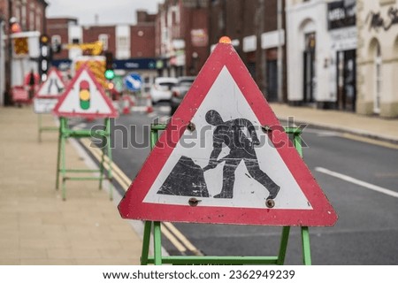 Road work sign against street in the background, information concept illustration.
