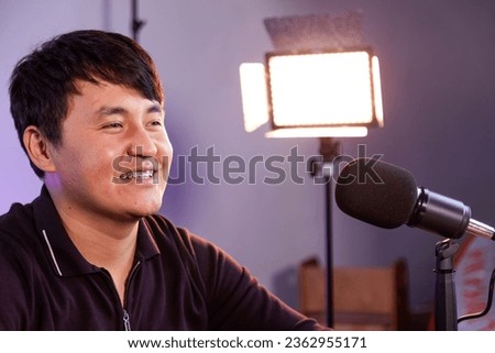 Closeup of asian man recording podcast with microphone in the studio