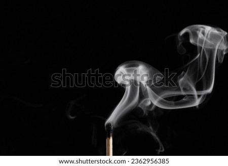 Smoke from a match that was just put out, isolated on black background.