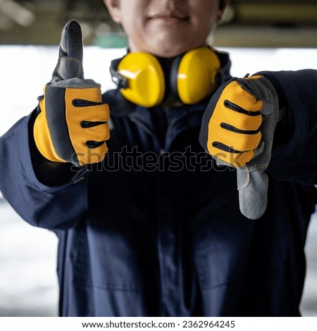 Pros and cons concept. Construction worker man with uniform suit, ear muffs and protective gloves showing thumbs up and thumbs down. Male engineer showing hand gesture sign at construction site