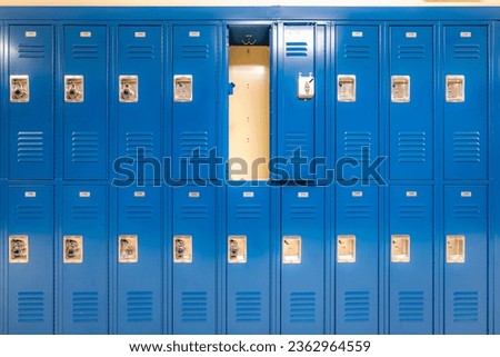 Single open empty blue metal locker along a nondescript hallway in a typical US High School. No identifiable information included and nobody in the hall.	 Royalty-Free Stock Photo #2362964559