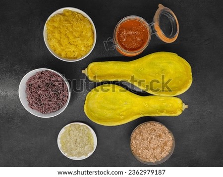 Stuffed zucchini recipe. Zucchini cut and emptied of its pulp, a bowl of pulp, a bowl of black and white rice, a bowl of sausage meat, a bowl of cooked onion and garlic, a jar of tomato sauce