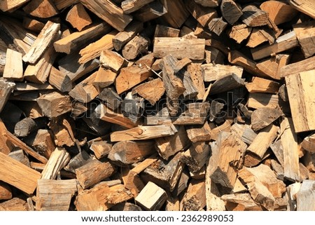 Firewood. Alternative and cheap energy source for heating. Heating season. Background and texture of wooden logs. Wooden fuel. Stock of renewable resources for the winter when energy prices rise