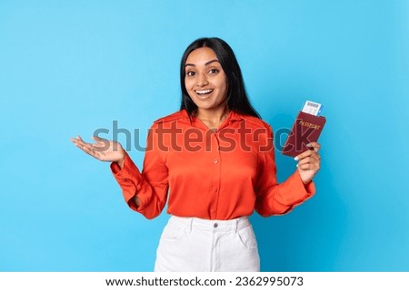 Travel Tour Offer. Excited Middle Eastern Tourist Woman Holding Boarding Pass And Passport Standing Over Blue Background, Glad About New Vacation Journey, Advertising Cheap Flight Tickets