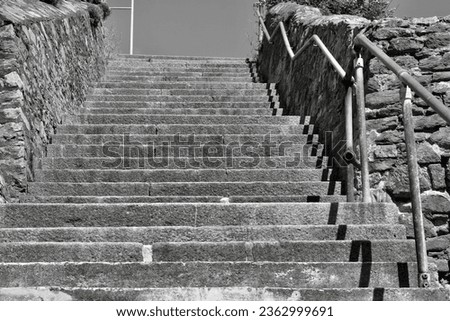 Black and white image of steep stone steps with dry stone wall on either side 