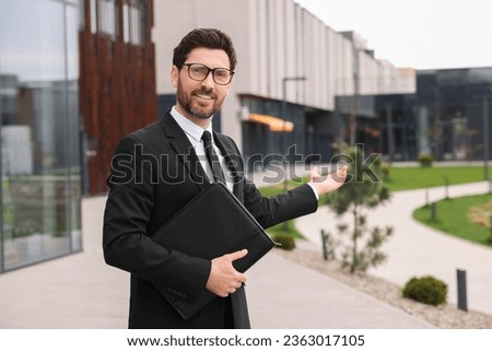 Real estate agent with leather portfolio outdoors. Space for text Royalty-Free Stock Photo #2363017105