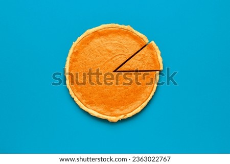 Top view with a homemade pumpkin pie minimalist on a blue colored table