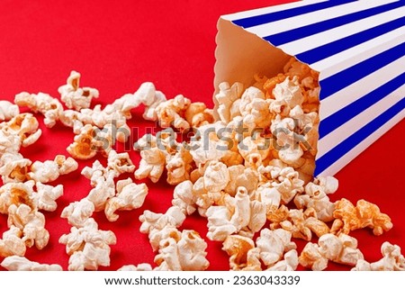 cardboard box with popcorn on a red background close-up