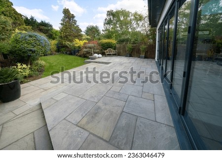 Beautiful indian sandstone patio with attractive garden and bifold doors. Royalty-Free Stock Photo #2363046479