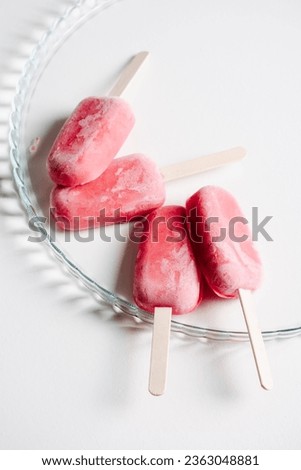Strawberry yogurt popsicle on a white background close-up. Summer treat.