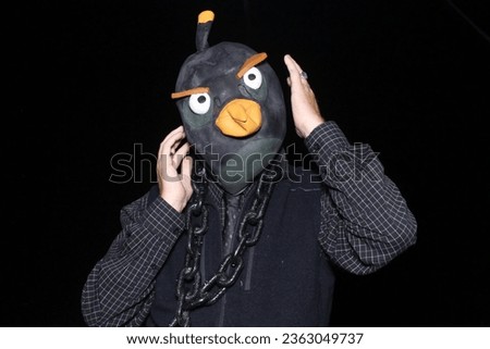 Halloween. Photo Booth. A man wears a Bird Head mask while having his pictures taken in a Photo Booth at a Halloween Party. Halloween is the Perfect time for a Photo Booth Party. Enjoy a Photo Booth. 