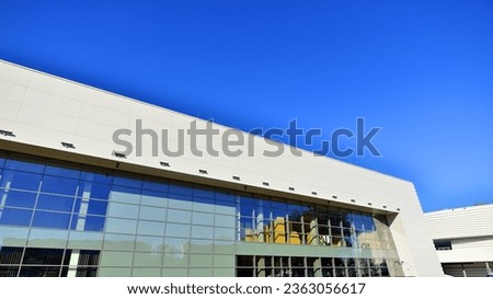 Minimalist photo of an exterior of a modern tin building with big glass showcases.