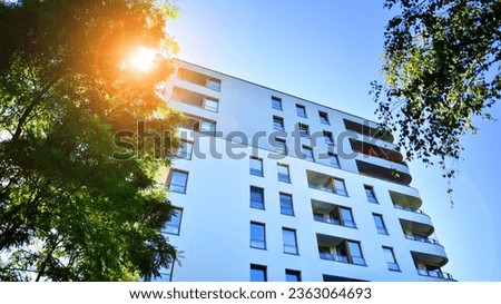 Modern apartment building and green trees. Ecological housing architecture. A modern residential building in the vicinity of trees. Ecology and green living in city, urban environment concept. 