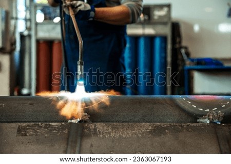 Heating up of metal construction with acetylene and oxygen burner in process of flame straightening with visible red colour of heated metal