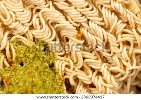 Texture of raw instant noodles with sprinkled flavoring.