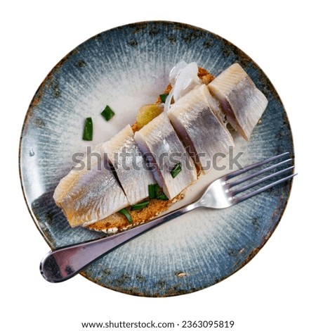 Delicious sandwich with slices of lightly salted herring fillet garnished with sweetish pickled onions. Popular European cuisine. Isolated over white background Royalty-Free Stock Photo #2363095819