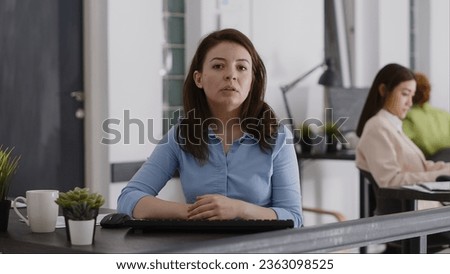 POV of entrepreneur meeting on telework videocall with colleagues, using online teleconference call to talk to people at office desk. Female employee chatting on internet conference. Tripod shot. Royalty-Free Stock Photo #2363098525