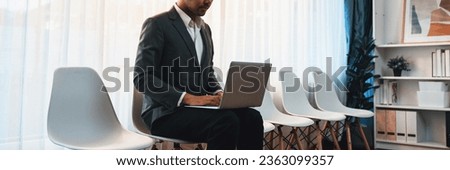 Job applicant waiting for interview in waiting room alone with empty chair on the corridor while applying on job application form. Modern employment and career seeker opportunity concept. Trailblazing