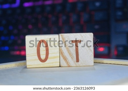 Photo of words with wooden block objects arranged into the word "OT" in English