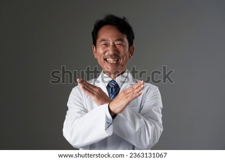 Asian middle aged doctor x sign gesture by hand in black background Royalty-Free Stock Photo #2363131067