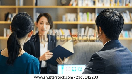 A middle-aged couple and a counselor having a conversation in the lobby. Financial planner. Advisor. Royalty-Free Stock Photo #2363142203