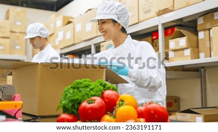 Workers in white coats packing vegetables in a warehouse. Royalty-Free Stock Photo #2363191171
