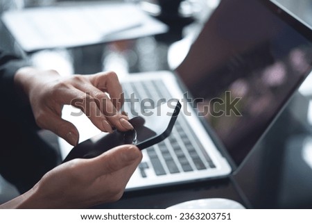 Close up, asian business woman using mobile phone during working on laptop computer at modern office, searching the information, surfing the internet, global internet networking, social media concept
