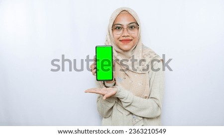 young asian woman showing copy space on her phone screen. Isolated over white background