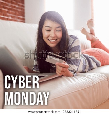 Cyber monday text over happy biracial woman lying on sofa using laptop and credit card online. Cyber monday, online shopping and sale promotion concept digitally generated image.