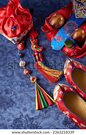 Traditional shoes and gifts on Korean script background Royalty-Free Stock Photo #2363218339